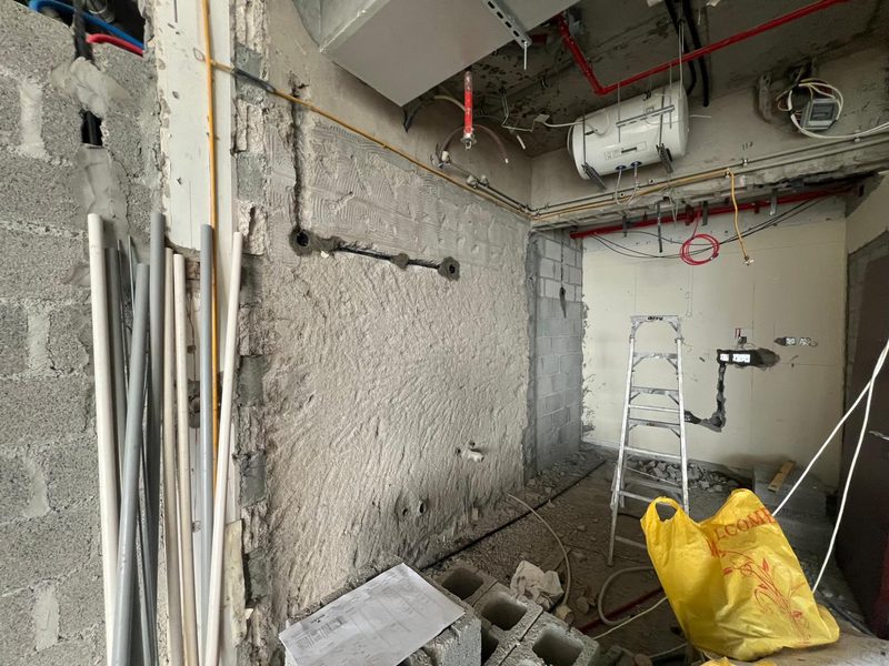 Kitchen wall rendered and services rerouted, with a water heater fixed overhead