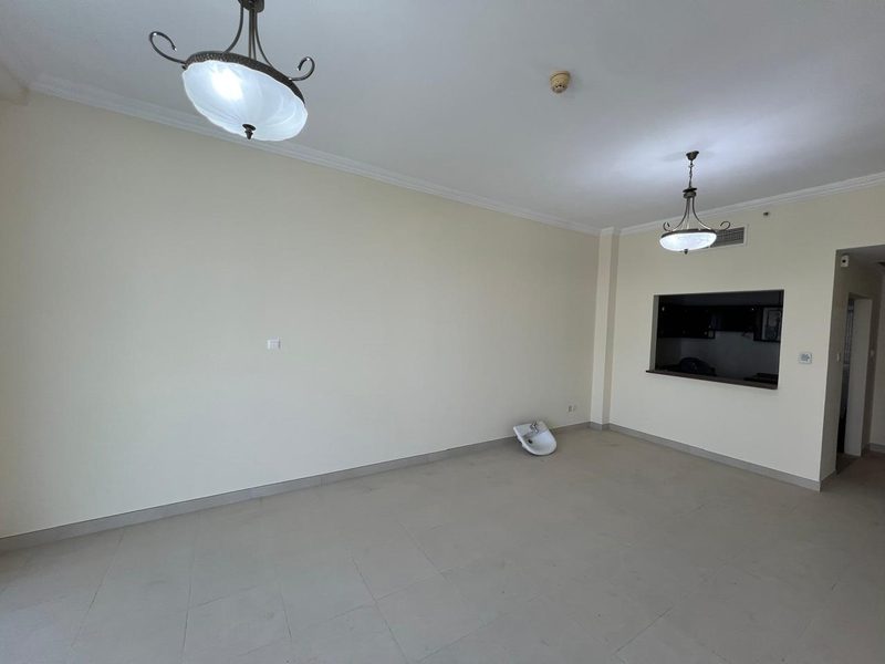 Living room before the works: plain cream walls, pendant lights and a serving hatch through to the old kitchen
