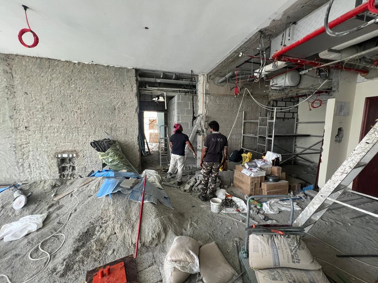 Living area stripped back: the future stone wall on the left, corridor opening in the middle, kitchen on the right