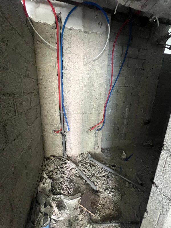 Master bathroom shower wall with new hot and cold supply lines and waste pipes