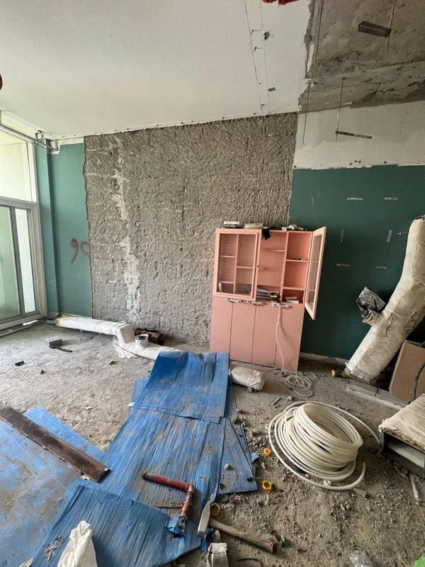 Master bedroom during strip-out, rendered wall between the original painted walls